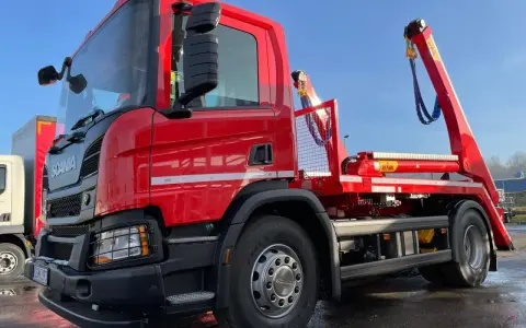 Czerwony hakowiec Scania gotowy do akcji. Sprawdź, jaka jest utylizacja gruzu cena za tonę, by pozbyć się odpadów budowlanych.