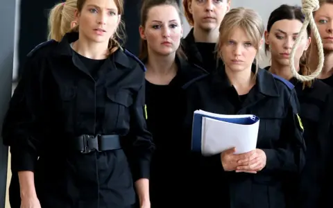 Grupa niebezpieczne kobiety w czarnych mundurach, jedna z nich trzyma teczkę, w tle sznur.