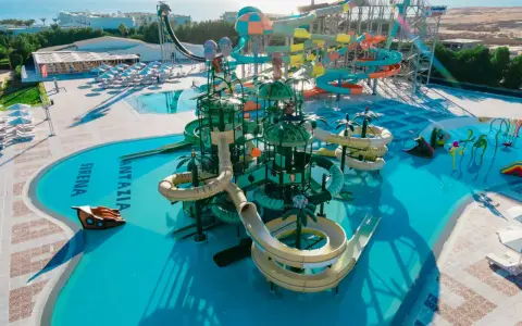 Kolorowy aquapark Fantazia Resort Marsa Alam z licznymi zjeżdżalniami i basenami, w tym z motywem statku pirackiego.