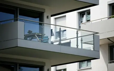 Nowoczesna loggia z przeszkloną balustradą, stolikiem i krzesłem. Idealne miejsce na poranną kawę.