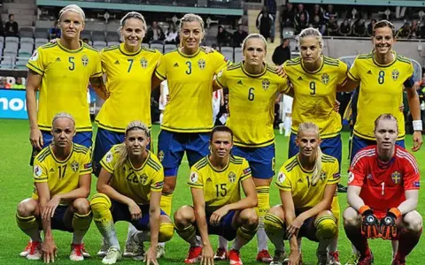 Sveriges damlandslag i fotboll, med lagkaptenen i spetsen, redo för match.