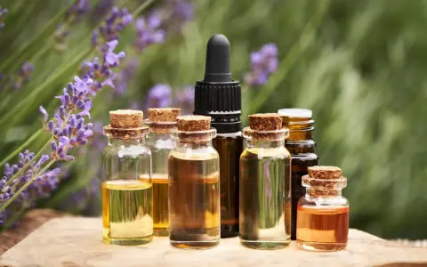 Bottigliette di oli essenziali, con lavanda sullo sfondo, che evocano le loro proprietà benefiche e naturali.