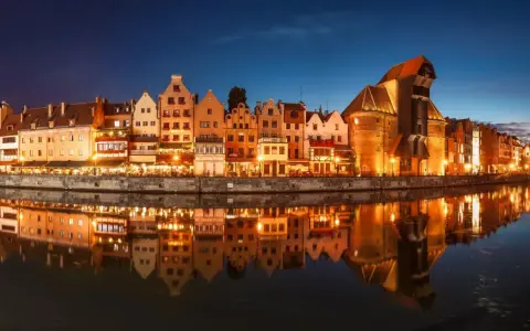 Nadmorska panorama Gdańska nocą, z odbijającymi się w wodzie kamienicami i Żurawiem. Idealne miejsce na zaręczyny Polska.
