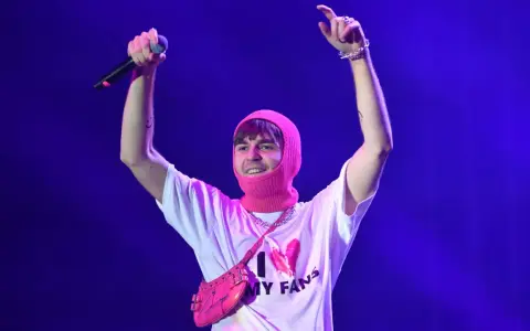 Mata z mikrofonem i różową kominiarką na głowie, w koszulce "I ❤️ MY FANS". Fani zastanawiają się, ile trwają koncerty Maty.