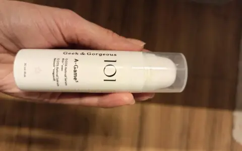 Dłoń trzyma serum Geek & Gorgeous A-Game 0.05% Retinal. Skóra wygląda na nawilżoną i promienną.