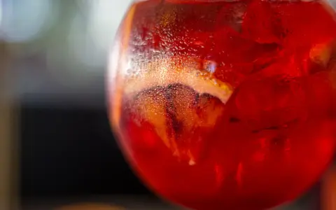 Orzeźwiający Martini Fiero drink z lodem i plasterkiem pomarańczy, skraplający się od zimna.