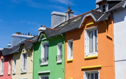 Maisonnettes colorées sous un ciel bleu. Idéal pour refaire sa façade soi-même et égayer son quartier.