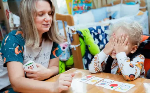 Kreatywne zabawy dla dzieci w wieku szkolnym: mama z synkiem grają w memory, rozwijając pamięć i spostrzegawczość.