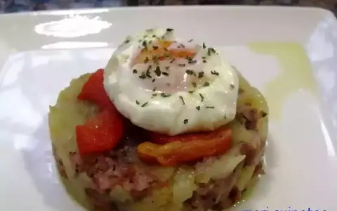 Delicioso timbal de patata con huevo escalfado y pimientos rojos, un plato que te hará chuparte los dedos.