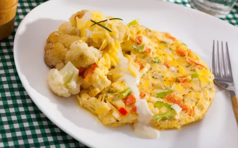 Pyszny omlet z warzywami i serem, podany z kalafiorem. Świetny pomysł, co zrobić z białek, gdy masz ochotę na coś lekkiego i sycącego.