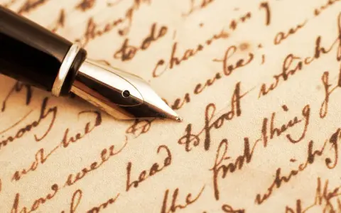 Pennino d'oro su pergamena antica, evocando il significato epistolare di un tempo.