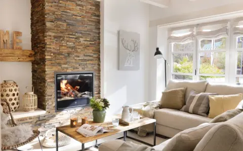 Acogedor salón moderno con chimenea de leña, sofá beige y mesa de centro de madera.