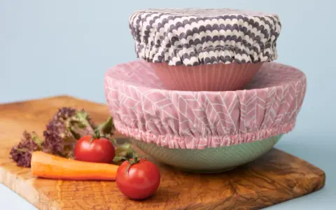 Trois couvre-plats en tissu avec des motifs différents, empilés sur des bols. Un tuto pour les réaliser soi-même.