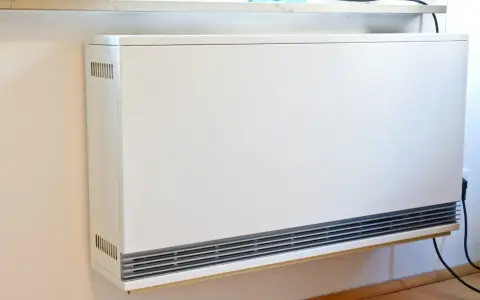 Ein weißer Nachtspeicherheizkörper an einer Wand. Der Austausch von Nachtspeicherheizungen ist Pflicht, um Energie zu sparen.