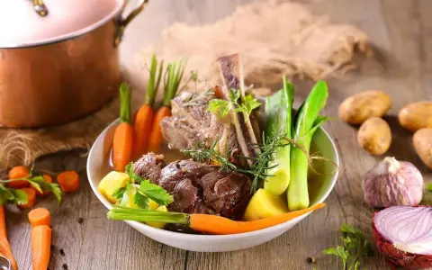 Un plat de pot-au-feu réconfortant avec du bœuf, des carottes, des poireaux et des pommes de terre, prêt à être dégusté.