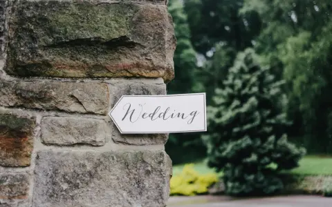 Strzałka z napisem "Wedding" wskazuje drogę do uroczystości, zapowiadając tradycyjny marsz weselny.