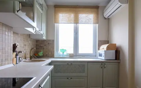 Cortinas de cocina de bambú sobre ventana, con microondas y panera de madera.