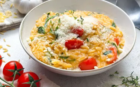 Cremiges Orzo-Rezept mit Kirschtomaten, Spinat und Parmesan. Ein köstliches Gericht, das schnell zubereitet ist.