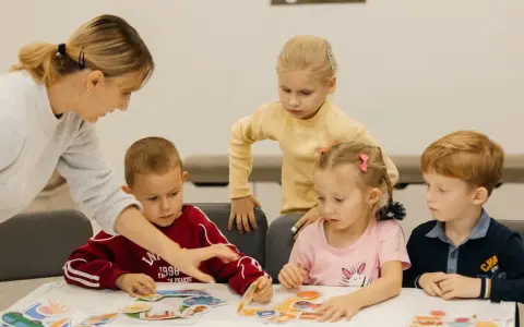 Nauczycielka pomaga dzieciom układać obrazki. Czy przedszkole może wypisać dziecko? Dzieci uczą się przez zabawę.