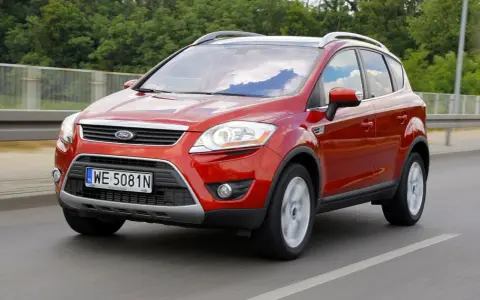 Czerwony Ford Kuga, idealny SUV do 40 tys. zł, jedzie po drodze.