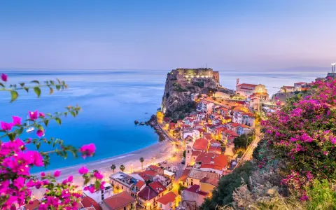 Scilla, Calabria: un borgo da sogno dove andare al mare, con il castello Ruffo a picco sul blu e fiori colorati.