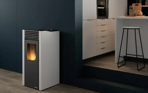 Estufa de pellets sin salida de humos con llama encendida, junto a una barra de cocina moderna.