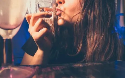 Młoda osoba pije alkohol. Pamiętaj, co grozi za picie alkoholu w wieku 17 lat: problemy zdrowotne i prawne.