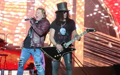 Axl Rose sjunger med Guns N' Roses i Sverige. Slash spelar gitarr med sin ikoniska hatt.
