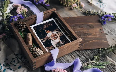Drewniane pudełko z fotografiami ślubnymi i wstążką. Idealny prezent na papierową rocznicę, pełen wspomnień i miłości.