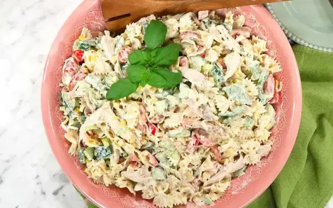 En krämig pastasallad med kyckling, grönsaker och en härlig basilika. Perfekt för ett snabbt pastasallad recept.