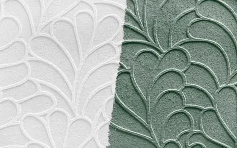 Papier peint en relief, moitié blanc, moitié vert, avec un motif de feuilles stylisées. Idéal pour peindre sur papier peint relief.