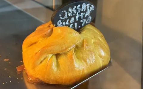 Złociste, pieczone ciasto z nadzieniem, typowe maltańskie jedzenie. Na tabliczce napis "Cassata Ricotta €1.70".