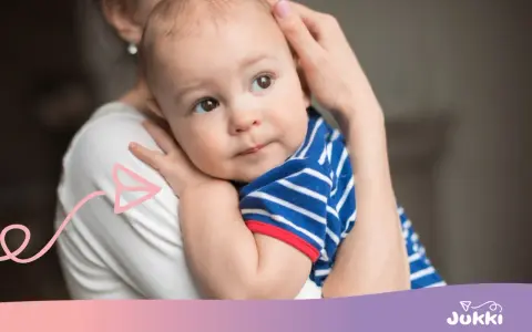 Ciepły uścisk mamy, kiedy dziecko zaczyna się przytulać. Maluch w pasiastym ubranku wtula się w nią z ufnością.