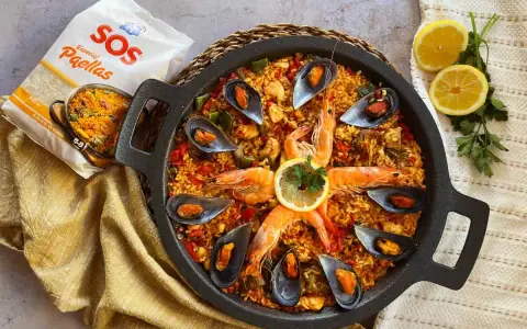 Paella mixta en paellera con gambas, mejillones, limón y bolsa de arroz SOS.