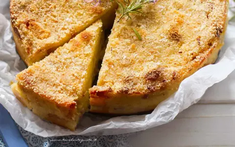 Delizioso gateau di patate dorato e croccante, guarnito con rosmarino fresco. Una fetta è già stata tagliata, invitando ad assaggiarlo.
