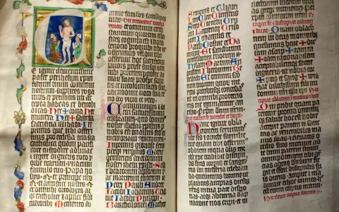 First Sunday of Advent readings from an illuminated manuscript. Jesus is depicted in the initial letter, with ornate borders and calligraphy.