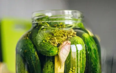 En burk med inlagda gurkor, dill och vitlök. Perfekt för ett gott saltgurka recept.