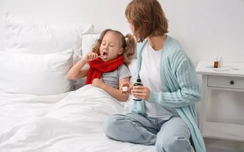 Bambina malata a letto prende sciroppo, mentre la mamma tiene il flacone. Forse per febbre o tosse, un mix di brufen e tachipirina insieme per farla stare meglio.