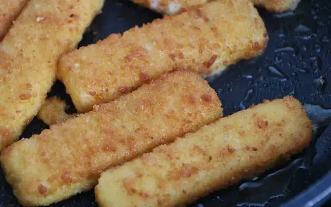 Gyldene fiskpinnar i ugn, redo att serveras. Krispiga och varma, en klassiker som alltid går hem.