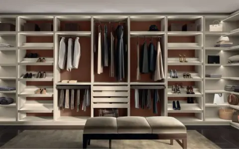 Una cabina armadio fai da te ben organizzata con abiti, scarpe e accessori ordinati su scaffali illuminati.