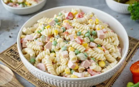 Ein cremiger, schneller Nudelsalat mit Spiralnudeln, Erbsen, Mais und Schinkenwürfeln. Perfekt für ein schnelles Mittagessen.