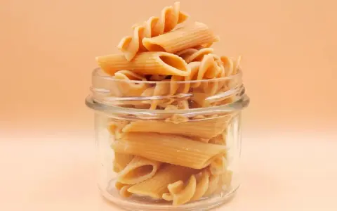 Słoik pełen makaronu penne i fusilli. Zastanawiasz się, ile czasu gotować makaron, by był idealny?