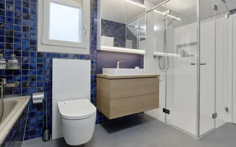 Modernt badrum med blå mosaik, flytande kommod och duschkabin. Perfekt badrum inspiration för ett stilrent hem.
