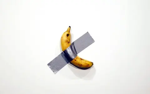 Une banane scotchée sur un mur blanc, une œuvre d'art conceptuelle qui fait réfléchir.