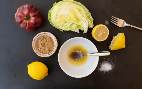 Zutaten für ein einfaches salatdressing mit zitrone und zucker: Eisbergsalat, Tomate, Zitronen, brauner Zucker und Salz.