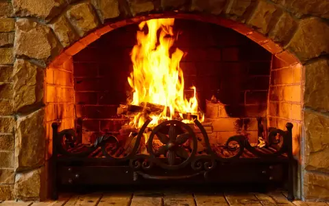 Chimenea de piedra con fuego crepitante. Aprende como encender la chimenea para crear un ambiente acogedor.