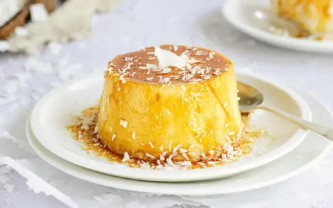 Delicioso flan de coco, cubierto con caramelo dorado y coco rallado, listo para disfrutar.