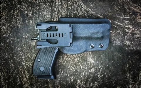Czarna kabura wewnętrzna na broń, dyskretnie ukrywająca pistolet.