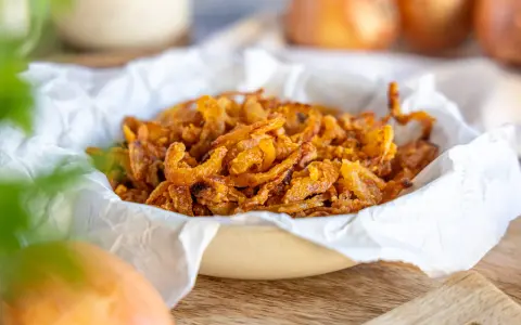 Knusprige frittierte Zwiebelringe in einer Schüssel, bereit zum Genießen.