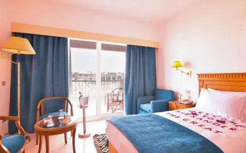 Pokój hotelowy z napisem "Welcome to Alexander the Great" na pościeli. Opinie o tym miejscu mogą być pozytywne.